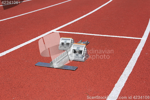 Image of Athletics starting blocks on race red track