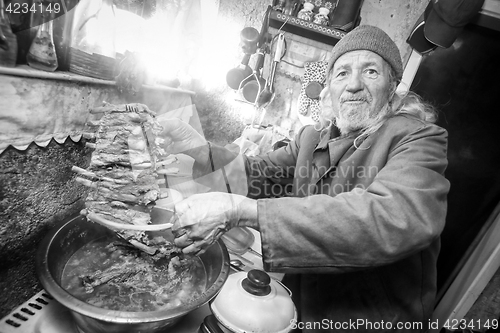 Image of Man boiling pork ribs bw