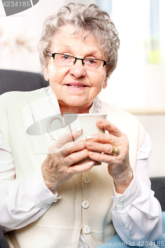 Image of The old lady drinking a brew of herbs Grandma&#39;s first aid kit, an infusion of herbs.