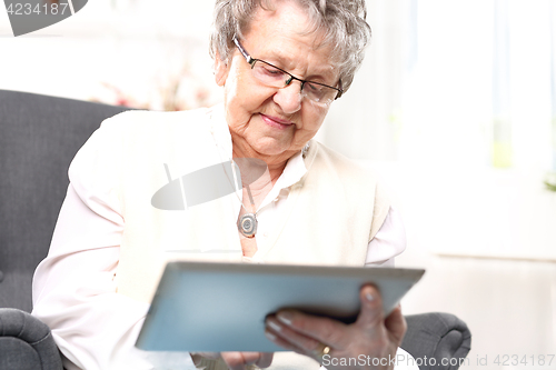 Image of Grandma and the computer. Older woman with a tablet.