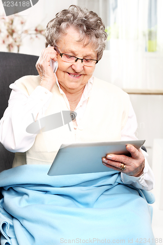 Image of Older woman with a tablet. Retired, entertainment on the Internet University of the Third Age.