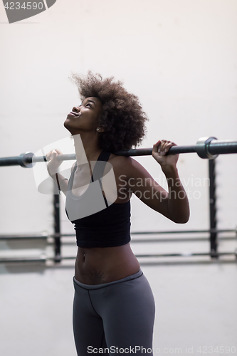 Image of black woman lifting empty bar