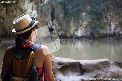 Image of Brunette in hat among mountains