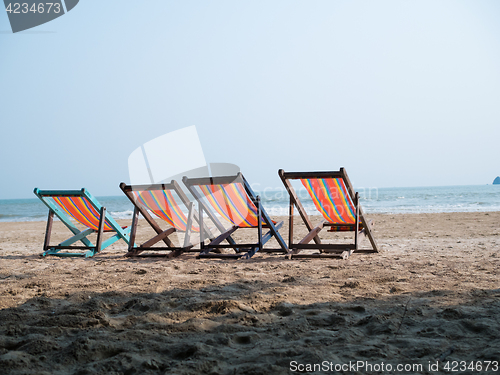 Image of Four deck chairs on beach