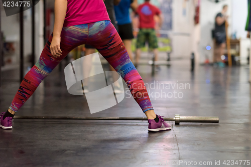 Image of a group of people exercise with an empty bar