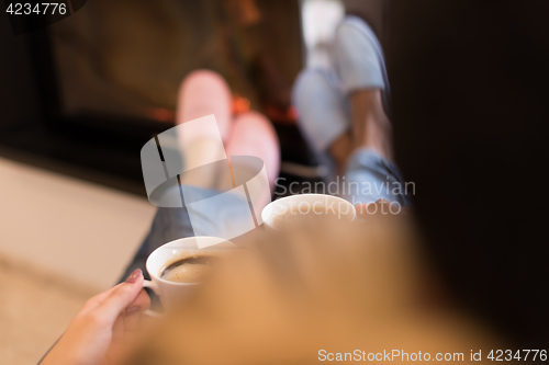 Image of Young multiethnic couple  in front of fireplace