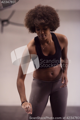 Image of black female athlete is performing box jumps at gym