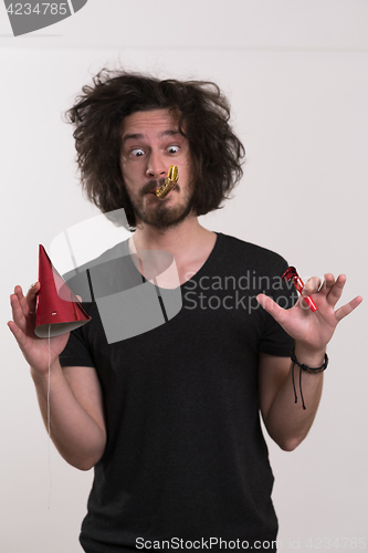 Image of Portrait of a man in party hat blowing in whistle