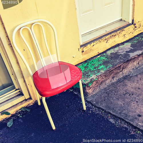 Image of Bright chair outside the house