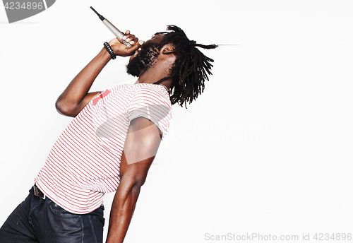 Image of young handsome african american boy singing emotional with microphone isolated on white background, in motion gesturing smiling, lifestyle people concept 