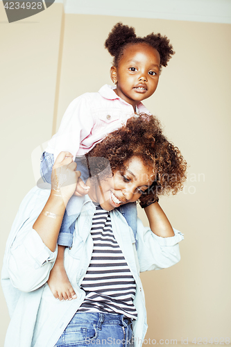 Image of adorable sweet young afro-american mother with cute little daughter, hanging at home, having fun playing smiling, lifestyle people concept, happy smiling modern family