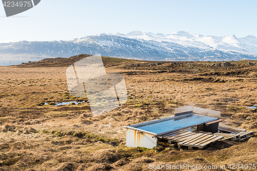 Image of Icelandic hotpot among the amazing lagoon and mountains