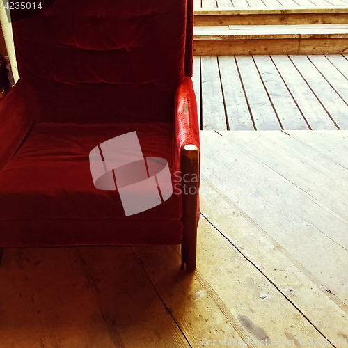 Image of Rustic interior with vintage red velvet armchair