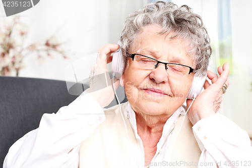 Image of Grandma listens to music. A moment of relaxation, rest grandmother listening to music.