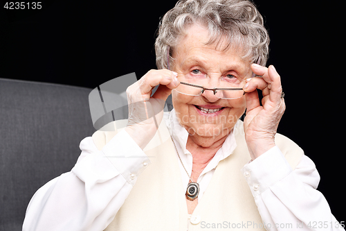 Image of Cheerful, smiling old woman sitting in the chair 