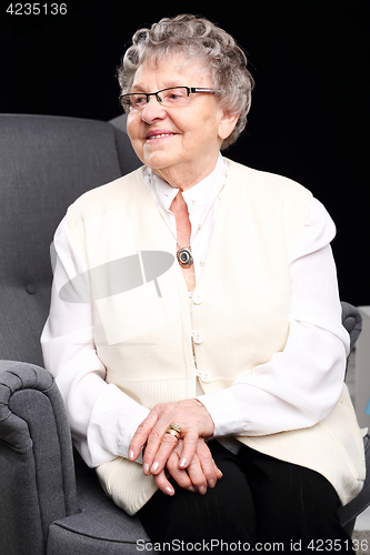 Image of Cheerful, smiling old woman sitting in the chair 