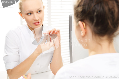 Image of The hearing aid for a child. A child with his mother at the ENT doctor. Smiling girl in ENT doctor  Cabinet laryngological. 