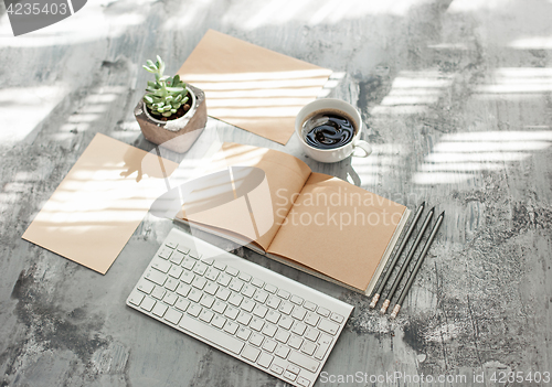 Image of Office desk table with computer, supplies and phone