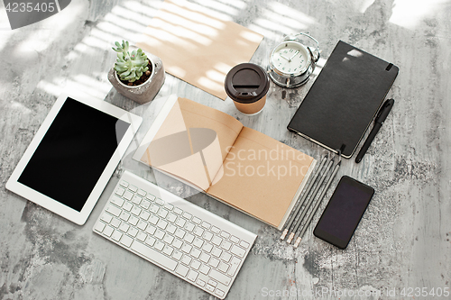 Image of Office desk table with computer, supplies and phone