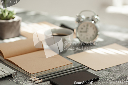 Image of Office desk table with computer, supplies and phone