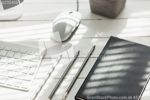 Image of Office desk table with computer, supplies and phone