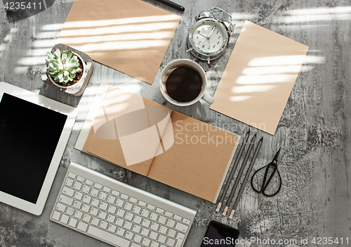 Image of Office desk table with computer, supplies and phone