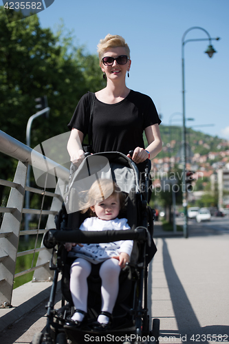 Image of mother pushed her baby daughter in a stroller