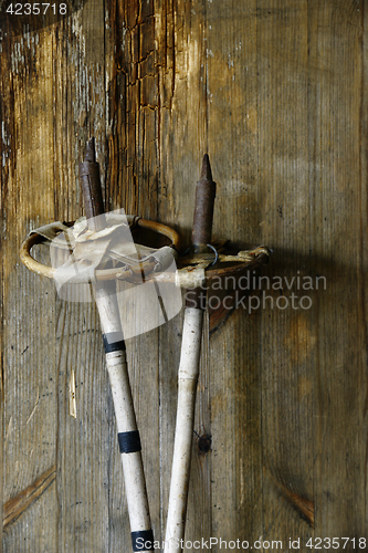 Image of old vintage ski poles on a wooden