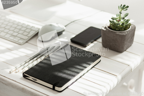 Image of Office desk table with computer, supplies and mobile phone