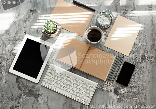 Image of Office desk table with computer, supplies and phone