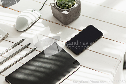 Image of Office desk table with computer, supplies and mobile phone