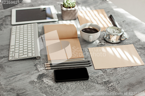 Image of Office desk table with computer, supplies and phone