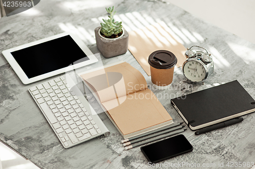 Image of Office desk table with computer, supplies and phone