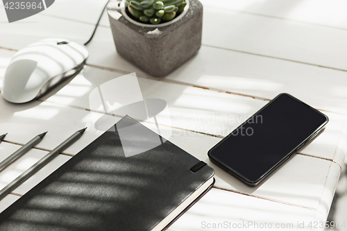 Image of Office desk table with computer, supplies and phone