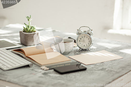 Image of Office desk table with computer, supplies and phone