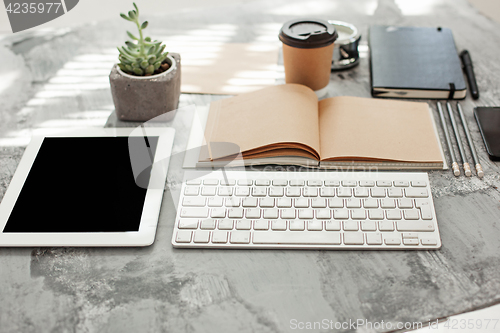 Image of Office desk table with computer, supplies and phone