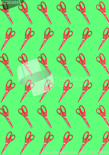 Image of top view of a many red colored plastic scissors on green background