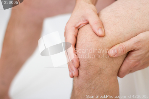 Image of Man holding his knee