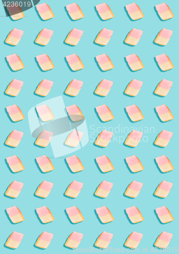 Image of white marshmallows on a blue background. geometric pattern of white marshmallows. top view