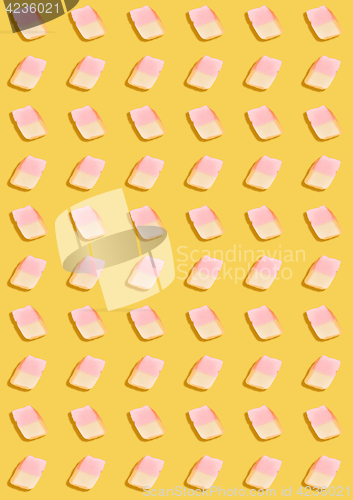 Image of white marshmallows on a yellow background. geometric pattern of white marshmallows. top view