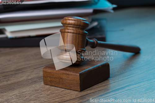 Image of Wooden table with hammer, papers