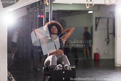 Image of black woman doing sit ups at the gym