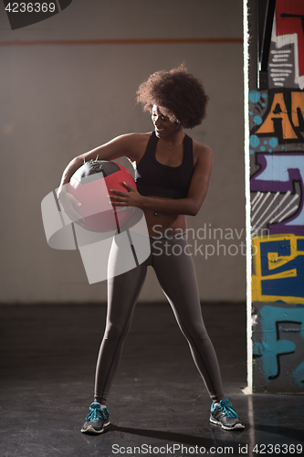 Image of black woman carrying crossfit ball