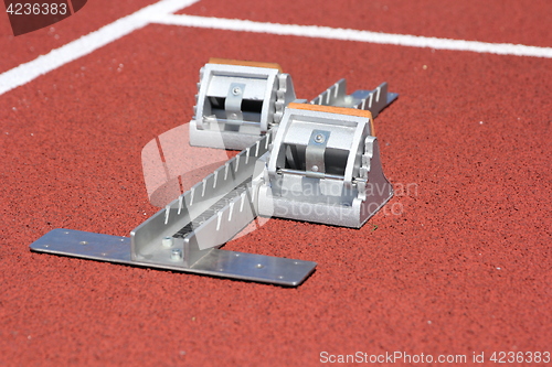 Image of Athletics starting blocks on race red track