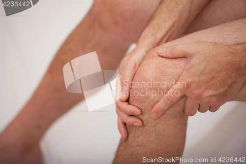 Image of Man holding his knee