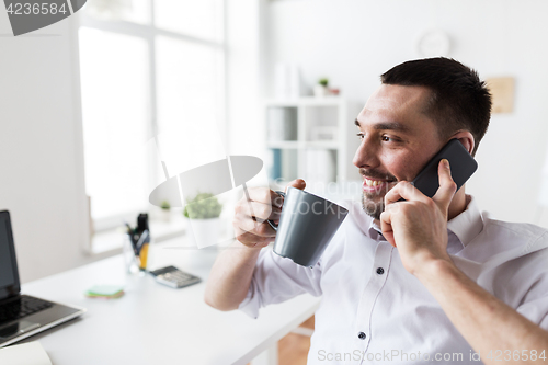 Image of businessman calling on smartphone at office