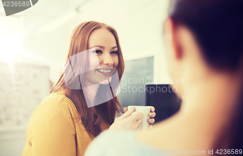 Image of happy creative team drinking coffee at office