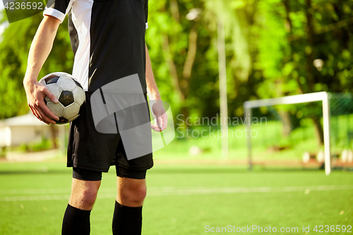 Image of soccer player with ball on football field