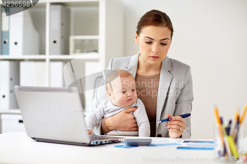 Image of happy businesswoman with baby and laptop at office