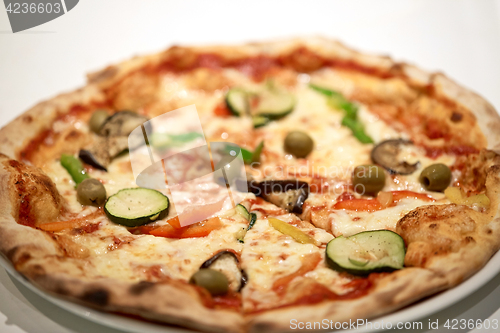 Image of close up of pizza on plate at pizzeria